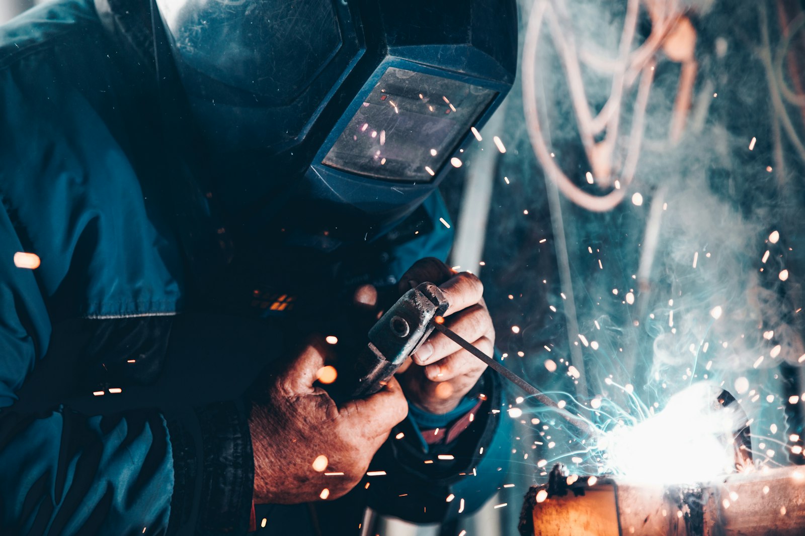 Welder at work on a factory floor, sparks flying